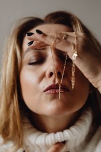 Kaboompics - Woman Holding a Cross Pendant in a Close-Up Faith Portrait