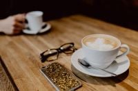 Kaboompics - Cup of coffee on table in cafe, iPhone mobile, glasses