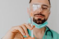 Kaboompics - Doctor Inspecting Vaccine Syringe Close-Up