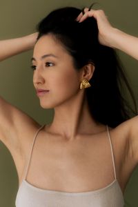 Kaboompics - Woman Adjusting Hair With Gold Earrings