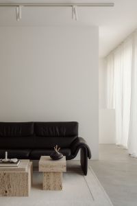Kaboompics - Wide Black Sofa and Travertine Tables in Neutral Room
