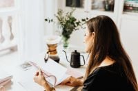Kaboompics - Woman Writing in a Notebook at a Home Office Desk with Pour-Over Coffee