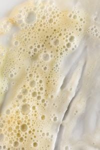Kaboompics - Golden Beige Skincare Foam with White Cream Swipe, Macro Texture