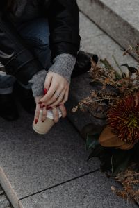 Kaboompics - Close Up of Woman Holding Coffee Beside Autumn Flowers