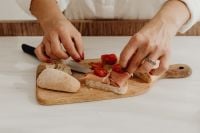 Kaboompics - Hands Assembling Prosciutto and Tomato Bruschetta