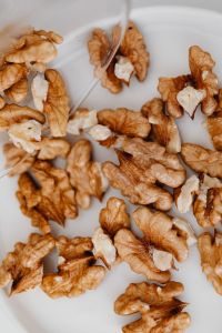 Kaboompics - Walnut Halves and Pieces Scattered on a White Surface, Healthy Pantry Ingredient