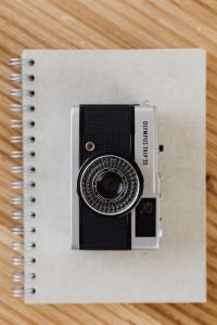 Kaboompics - Close Crop of Olympus Camera Body and Lens on a Notebook