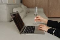 Kaboompics - Laptop, Wine Glass and Hand on a Minimalist Sofa