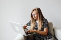 Kaboompics - Young Woman Working on Laptop in Armchair