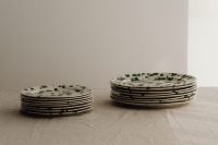 Kaboompics - Two Green Splatter Plate Stacks across a Linen Tabletop