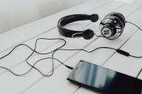 Kaboompics - Close-Up of a Smartphone beside Wired Headphones on White Wood