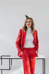 Kaboompics - Smiling Woman in Red Sequin Suit and White Turtleneck on White Background