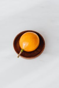 Kaboompics - Passion Fruit in a Wooden Bowl with Marble Copy Space for Healthy Recipe Graphics