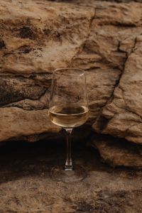 Kaboompics - White Wine Glass on a Rocky Seaside Ledge
