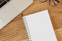 Kaboompics - Open Blank Spiral Notebook Beneath a Laptop and Eyeglasses on Wood, Minimal Office Background