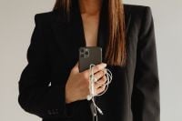 Kaboompics - Businesswoman Holding a Smartphone and Earphones in a Black Suit