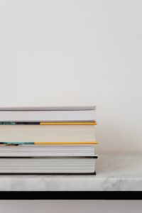 Kaboompics - Partial Book Stack and Marble Table Against a Blank White Wall