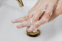 Kaboompics - Close-Up of Soapy Hands over a Bathroom Sink Drain for Hand Hygiene Education