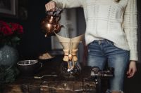 Kaboompics - Woman Pouring Hot Water through a Chemex Coffee Filter at a Rustic Home Table