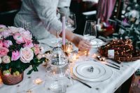 Kaboompics - Hands Arranging Wine Glasses beside Pink Christmas Flowers