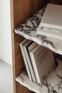 Kaboompics - Book Spines and Reading Pages on a Marble Shelf in a Walnut Bookcase