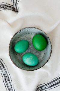 Kaboompics - Overhead Green Easter Eggs in a Ceramic Bowl on White Linen