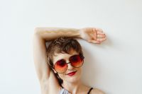 Kaboompics - Woman in Sunglasses Showing Rainbow Paint on Her Raised Arm