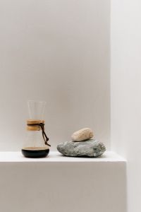 Kaboompics - Minimal Glass Chemex and Stacked Stones on White Pedestal