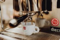 Kaboompics - White Espresso Cup Beneath a Commercial Coffee Machine at a Café