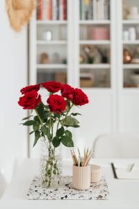 Kaboompics - Red Roses, Pencil Cup and Open Notebook on Home Office Desk, Vertical Still Life