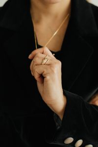 Kaboompics - Woman Pinching Gold Necklace Chain Over Black Outfit