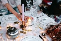 Kaboompics - Hands Arranging Christmas Table Decor beside White Plates