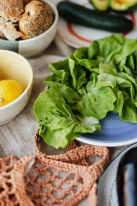 Kaboompics - Fresh Lettuce Leaves on a Blue Plate with Bread and Lemon