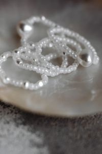 Kaboompics - Macro Photo of Pearl Bead Strands Draped Over a Seashell