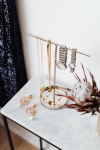 Kaboompics - Vertical Jewelry Stand with Watches and Gold Chains on Marble Table beside Dried Florals