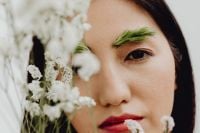 Kaboompics - Close-Up Asian Portrait with One Eye Visible Through White Wildflowers and Green Brows