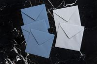 Kaboompics - Four Blue and White Envelopes on Black Marble, Overhead Stationery Mockup