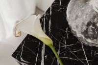 Kaboompics - Calla Lily on Black Marble Table beside White Fabric and Stone Decor