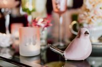 Kaboompics - Glossy Pink Ceramic Bird Figurine beside a Frosted Candle, Soft-Focus Easter Decor