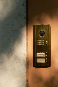 Kaboompics - Vintage Brass Doorbell Intercom on Pink Stucco Wall, Italy