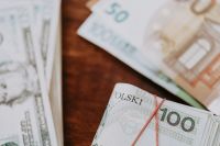 Kaboompics - Polish Zloty Notes with Euro Cash in the Background, Currency Close-Up on Wood