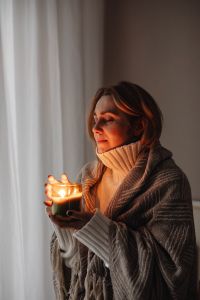 Kaboompics - Cocooning at Home: Woman Holding a Candle Under a Blanket