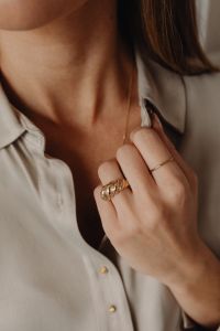 Kaboompics - Woman Opening Tan Silk Shirt Wearing Gold Rings