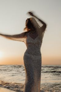 Kaboompics - Motion Blur Woman in Sequin Dress by Ocean at Golden Hour