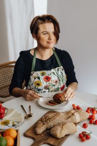 Kaboompics - Woman in a Floral Apron Cutting a Round Vegetable on a Plate