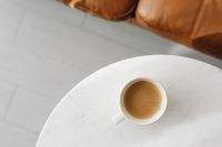 Kaboompics - White Coffee Cup on Marble Table Beside Leather Sofa for Minimalist Interior Design