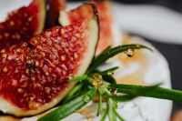 Kaboompics - Macro Figs and Dew-Covered Rosemary on a White Cheese Background