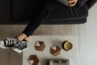 Kaboompics - Relaxed Sofa Break with Sneakers, Books and Coffee Mug by Living Room Table
