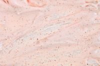 Kaboompics - Sheer Peach Exfoliating Cream Spread with Fine Brown Specks, Skincare Macro Texture
