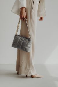 Kaboompics - Gray Quilted Chain Strap Bag Carried at the Side of Beige Trousers